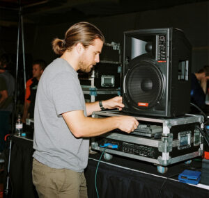 Technician installing event speakers for audio visual setup